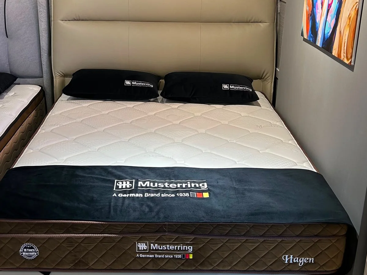 Musterring Hagen queen mattress on a storage bedframe with a cream padded headboard